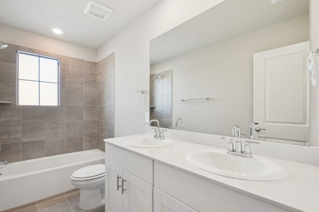 full bathroom with tile patterned floors, toilet, tiled shower / bath combo, and vanity