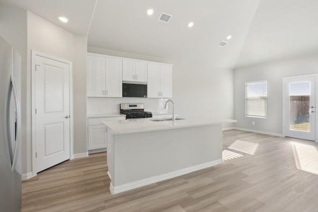 kitchen with sink, appliances with stainless steel finishes, tasteful backsplash, an island with sink, and white cabinets