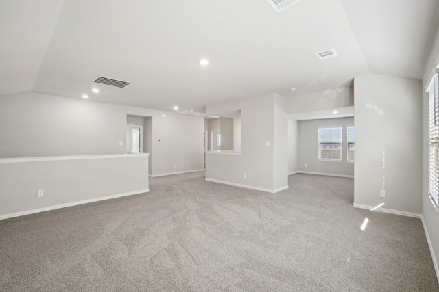 spare room with lofted ceiling and light colored carpet