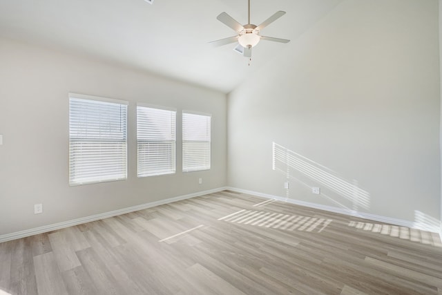 spare room featuring lofted ceiling, ceiling fan, and light wood-type flooring