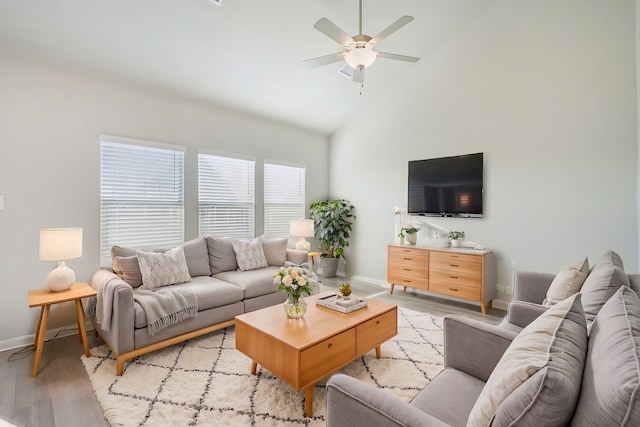 living room with ceiling fan, lofted ceiling, and light hardwood / wood-style floors