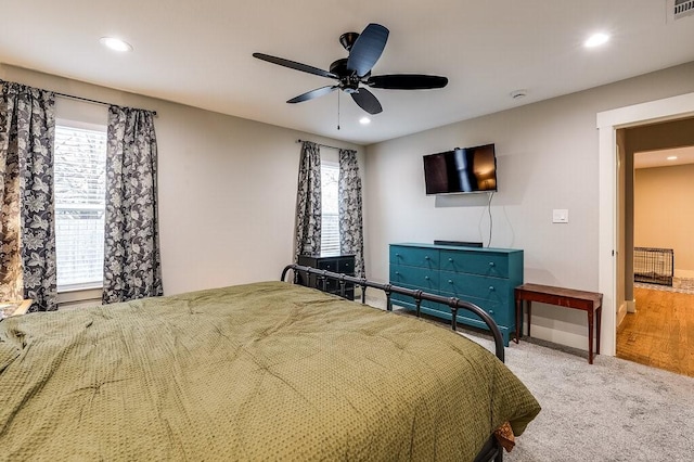 carpeted bedroom with multiple windows and ceiling fan