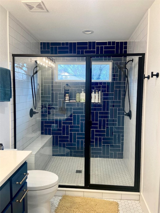 bathroom with vanity, tile patterned flooring, a shower with door, and toilet