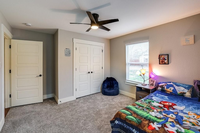 carpeted bedroom featuring ceiling fan and a closet