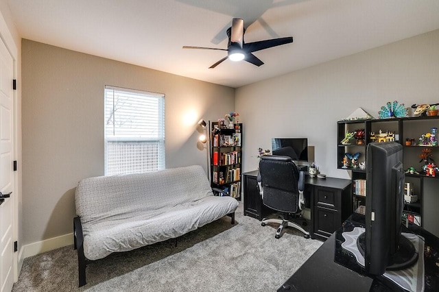 carpeted office space featuring ceiling fan