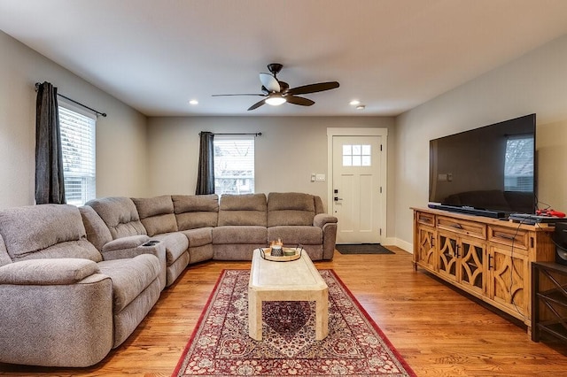 living room with ceiling fan, plenty of natural light, and light hardwood / wood-style floors