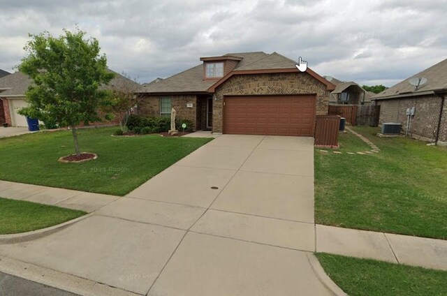 view of front of property featuring cooling unit, a garage, and a front yard