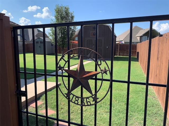 view of gate featuring a storage unit and a lawn