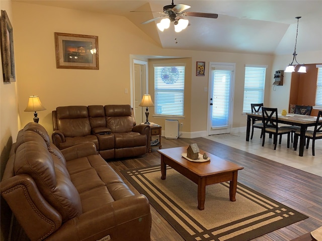 living room featuring lofted ceiling, dark wood-type flooring, and ceiling fan