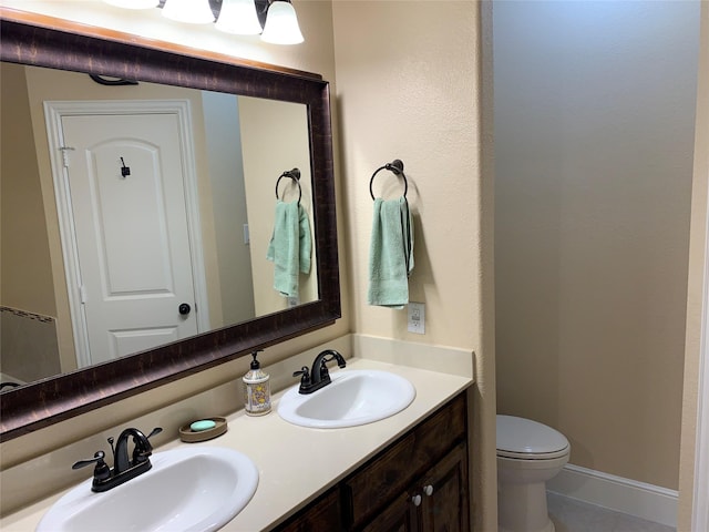 bathroom with tile patterned flooring, vanity, and toilet