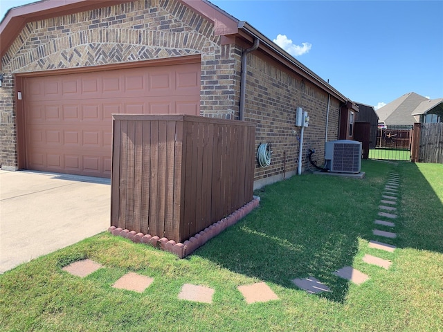 view of side of home featuring a garage, an outdoor structure, a lawn, and central air condition unit