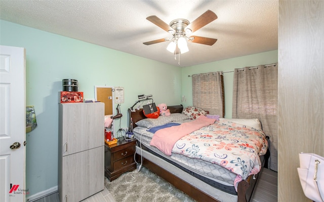 carpeted bedroom with ceiling fan and a textured ceiling