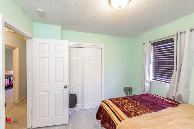 bedroom with a textured ceiling and a closet