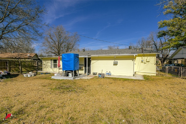 back of house with a yard and a patio