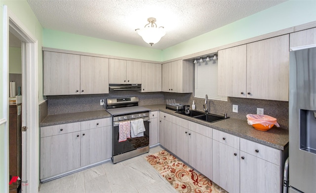 kitchen with appliances with stainless steel finishes, sink, a textured ceiling, and backsplash