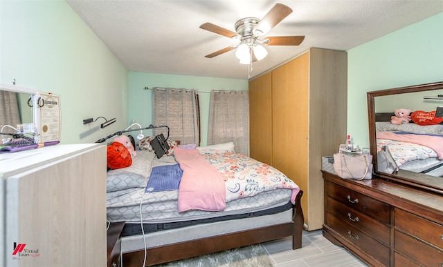 bedroom with ceiling fan and a textured ceiling