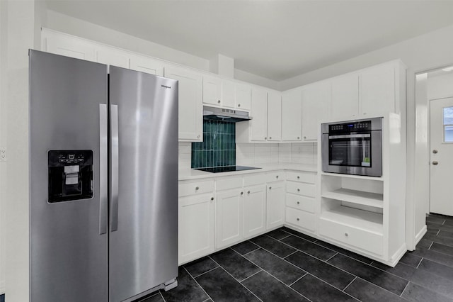 kitchen with stainless steel appliances, white cabinetry, tasteful backsplash, and dark tile patterned flooring