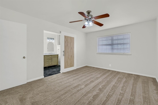 unfurnished bedroom with ceiling fan, carpet, and ensuite bath