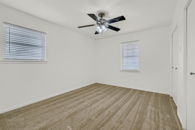 carpeted spare room with ceiling fan