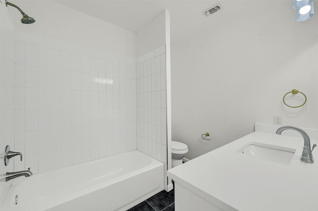 full bathroom featuring tile patterned flooring, tiled shower / bath, vanity, and toilet