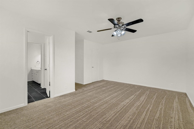 empty room featuring ceiling fan and dark carpet