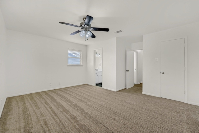 unfurnished bedroom featuring connected bathroom, light colored carpet, and ceiling fan