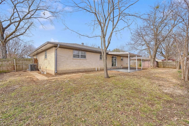 back of property featuring a lawn, a patio, and central air condition unit