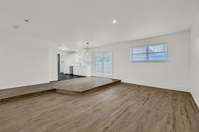 unfurnished living room with sink and wood-type flooring