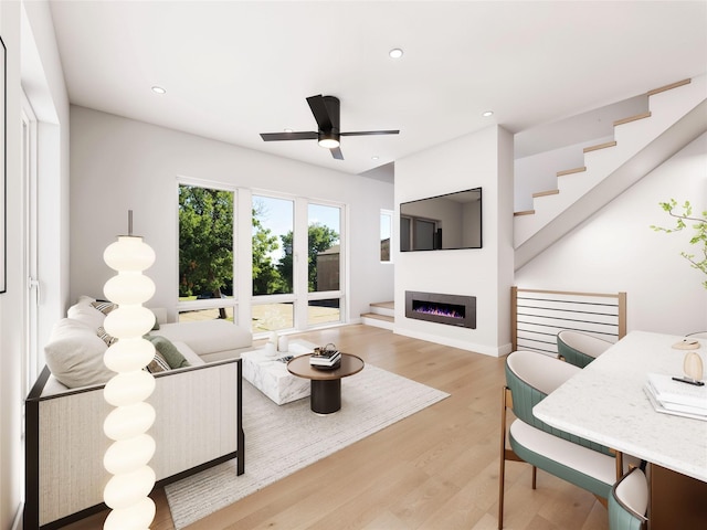 living room with light hardwood / wood-style flooring and ceiling fan