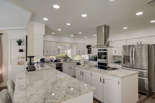 kitchen featuring white cabinetry, island exhaust hood, appliances with stainless steel finishes, and light stone counters