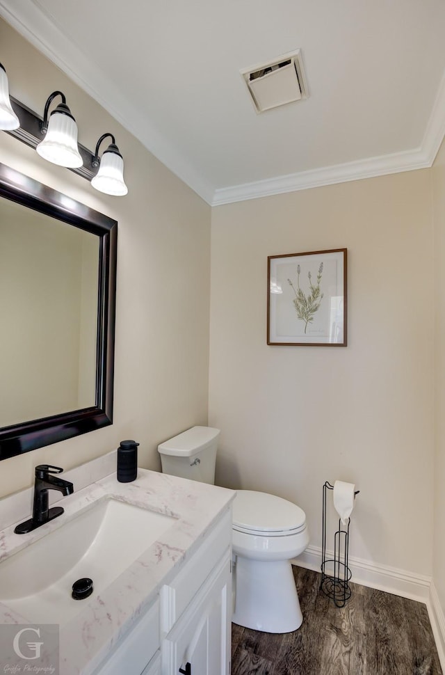 bathroom featuring hardwood / wood-style flooring, vanity, crown molding, and toilet