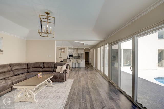 living room featuring crown molding, hardwood / wood-style floors, and a chandelier