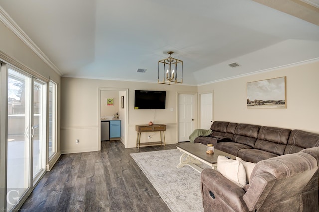 living room with crown molding, dark hardwood / wood-style floors, and an inviting chandelier