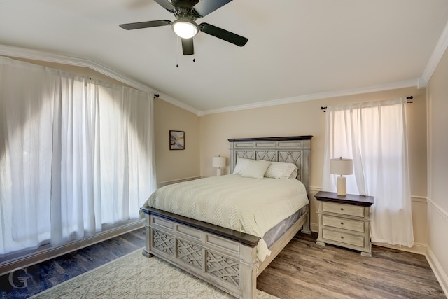 bedroom featuring vaulted ceiling, ornamental molding, hardwood / wood-style floors, and multiple windows