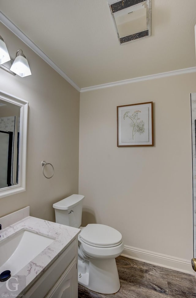 bathroom with vanity, wood-type flooring, ornamental molding, and toilet