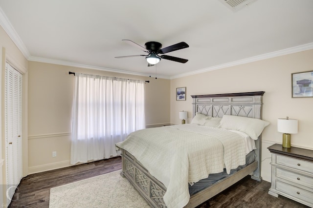 bedroom featuring dark wood-type flooring, ornamental molding, and ceiling fan