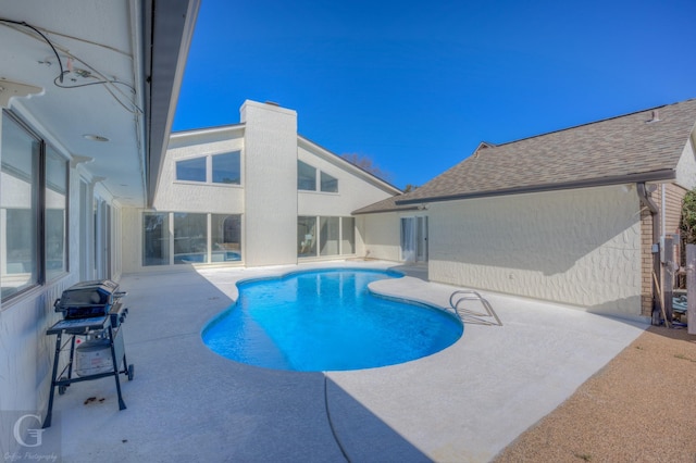 view of swimming pool with a grill and a patio