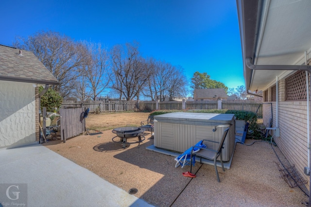 view of yard featuring a hot tub, a patio, and a fire pit