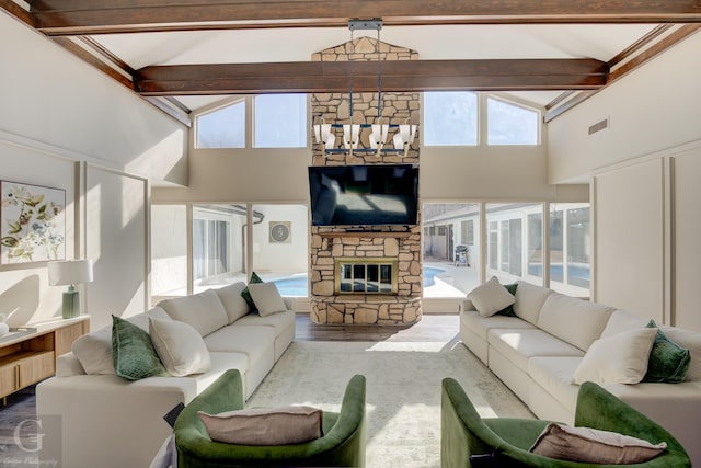 living room featuring a stone fireplace, high vaulted ceiling, beamed ceiling, a chandelier, and hardwood / wood-style flooring