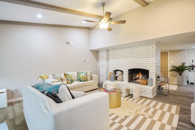 living room featuring high vaulted ceiling, beamed ceiling, ceiling fan, a fireplace, and hardwood / wood-style floors