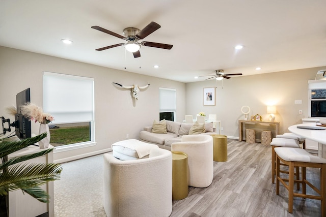 living room featuring light hardwood / wood-style flooring and ceiling fan