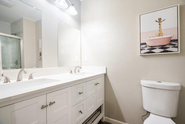 bathroom with vanity, a shower with shower door, and toilet