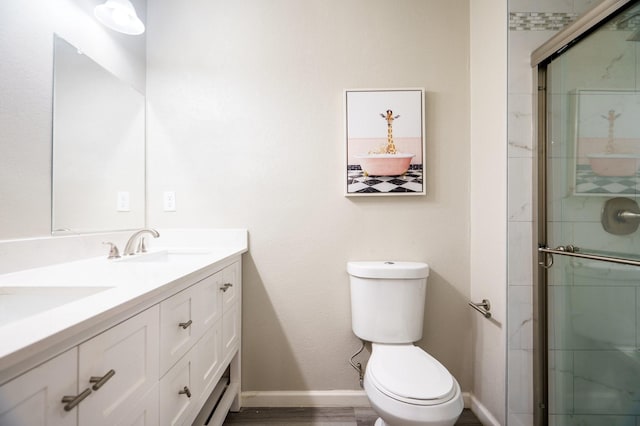 bathroom featuring vanity, toilet, an enclosed shower, and hardwood / wood-style floors