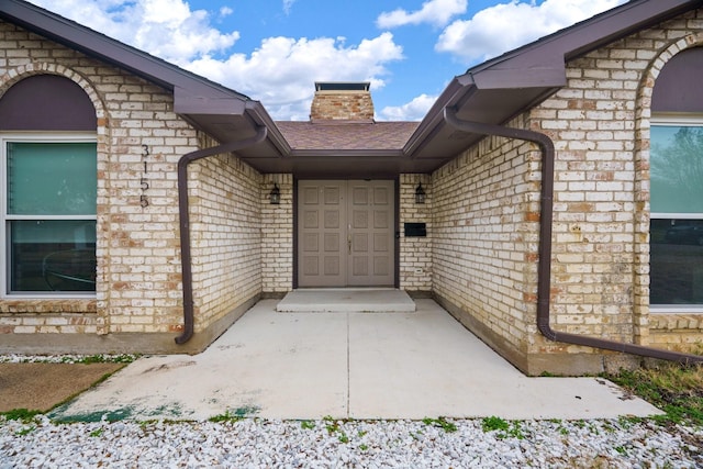 view of exterior entry with a patio