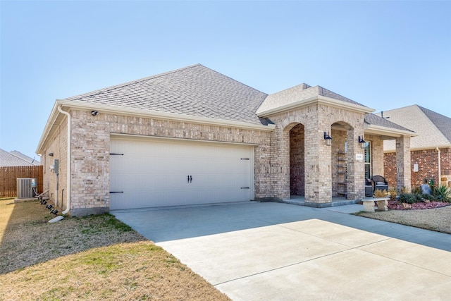 view of front of property with a garage and central AC unit