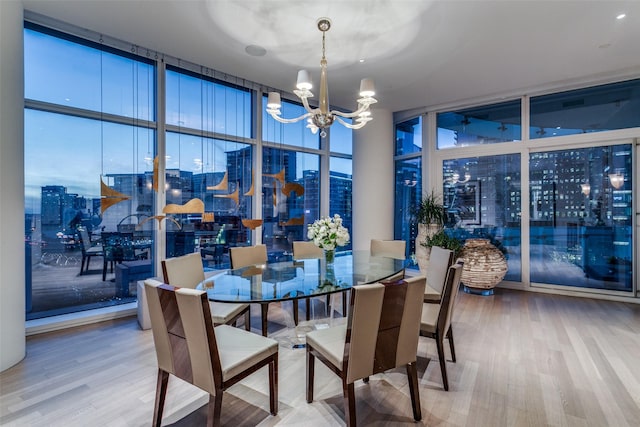 dining space featuring a notable chandelier, wood-type flooring, and expansive windows