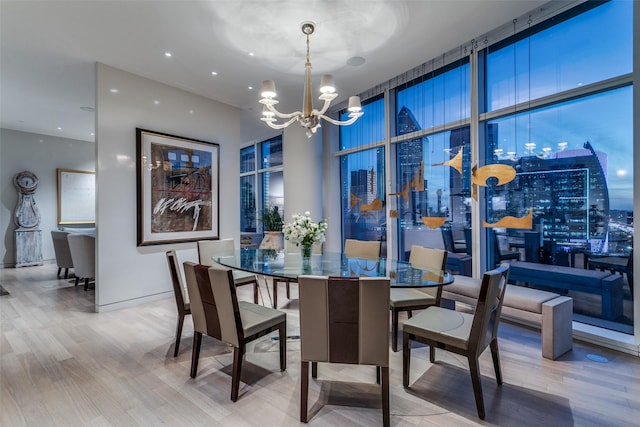 dining area with expansive windows, hardwood / wood-style floors, and a notable chandelier