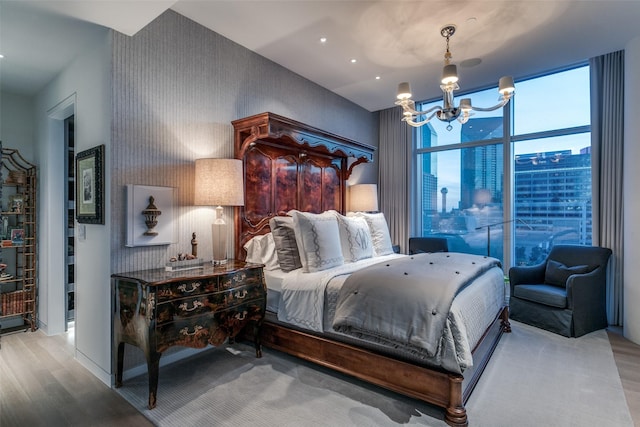 bedroom featuring hardwood / wood-style floors, a wall of windows, and a chandelier