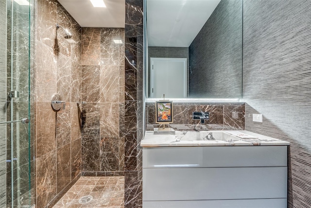 bathroom with vanity, tile walls, and a tile shower