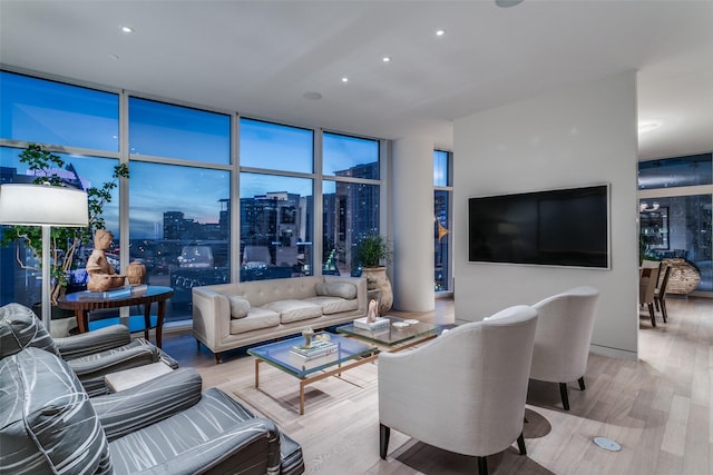 living room with expansive windows and light hardwood / wood-style flooring